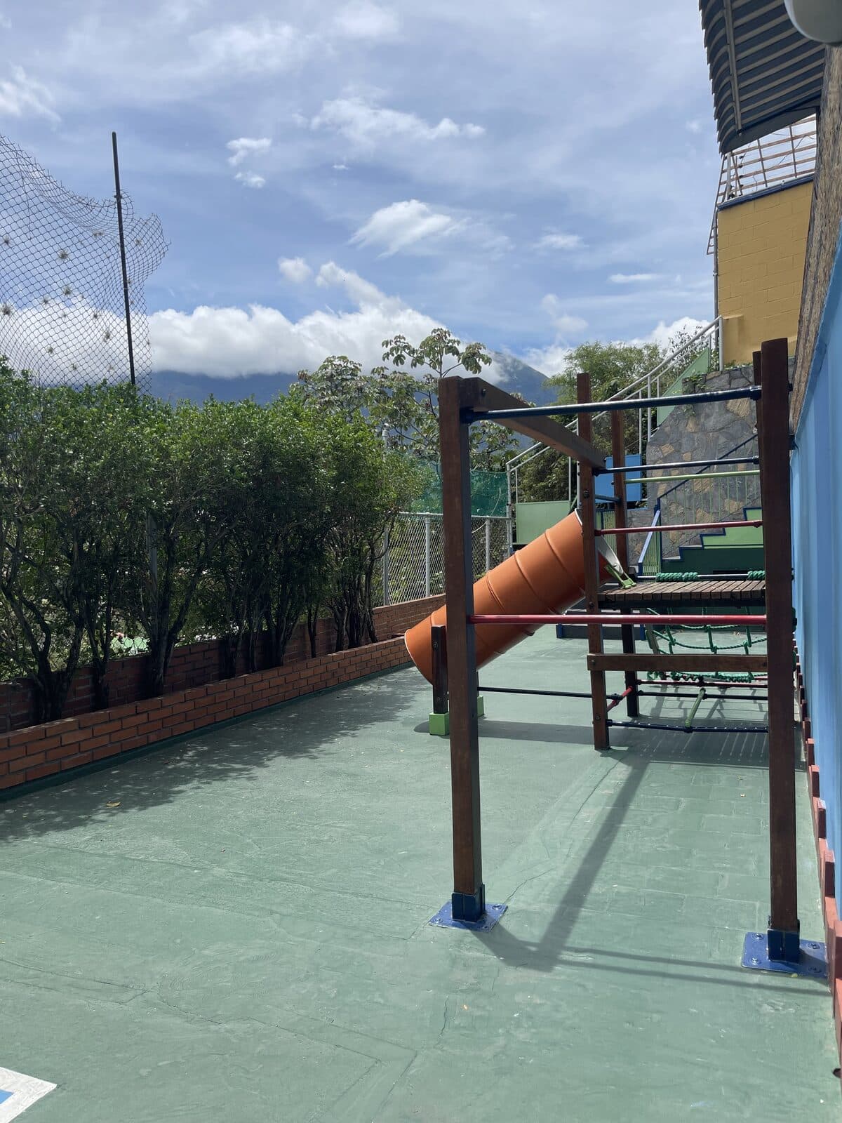 Patio de recreo con juegos y las montañas de Caracas de fondo